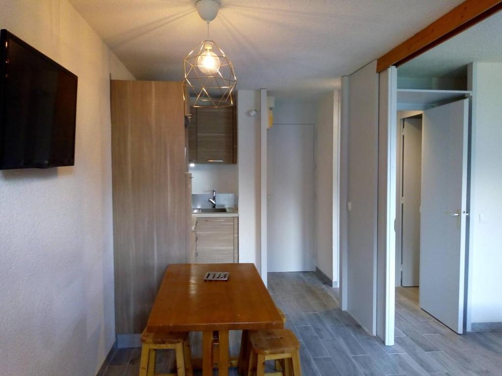une salle à manger avec une table en bois et une cuisine dans l'établissement Appart cosy avec accès pistes et commerces, balcon, parking, animaux ok! - FR-1-355-24, à Les Allues