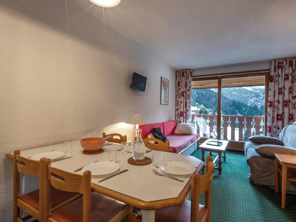 un salon avec une table, des chaises et un canapé dans l'établissement Appartement confortable à Méribel, 6 couchages, balcon exposé Sud - FR-1-355-57, à Méribel