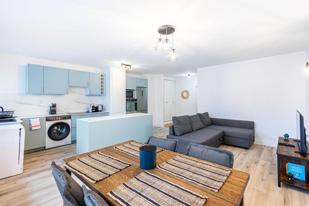 une cuisine et un salon avec une table et un canapé dans l'établissement GuestReady - Séjour Élégant à Paris pour 6, à Paris