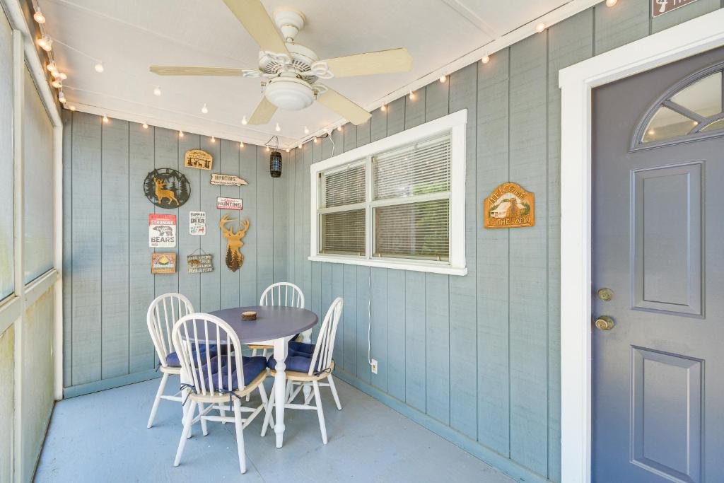 Un comedor con mesa y sillas y un ventilador de techo. en Pet-Friendly Fort McCoy Cabin with Fire Pit!, en Orange Springs