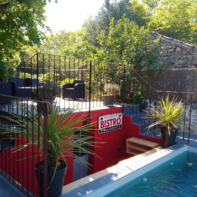 une piscine avec un panneau de bistrot sur le côté d'une clôture dans l'établissement Le Souliadou, à Saint-Didier