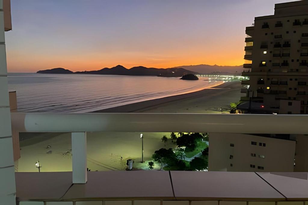 uma vista da praia ao pôr do sol de um edifício em SHB - Paradisíaca vista para o mar no Gonzaga! em Santos
