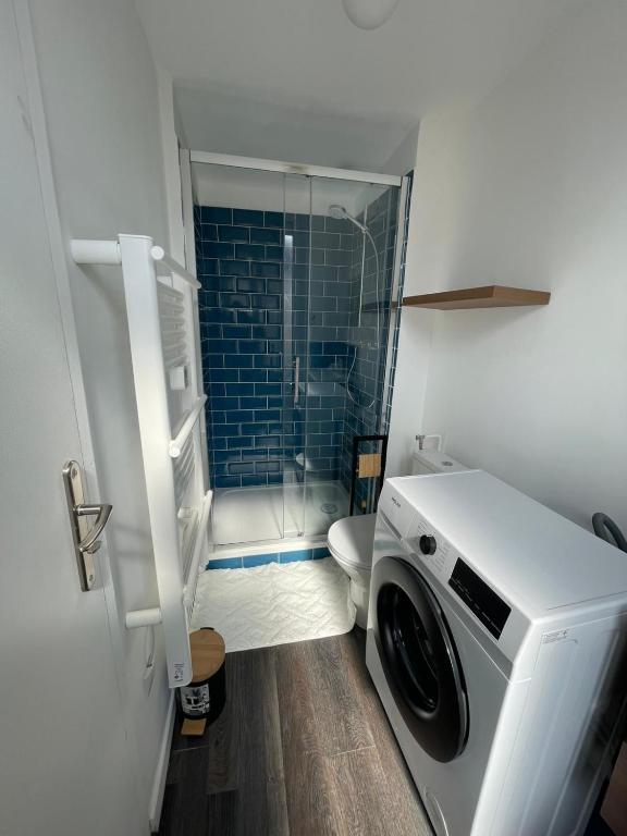 una lavatrice in un bagno con doccia di Blue Vervet - T2 avec parking a Vierzon