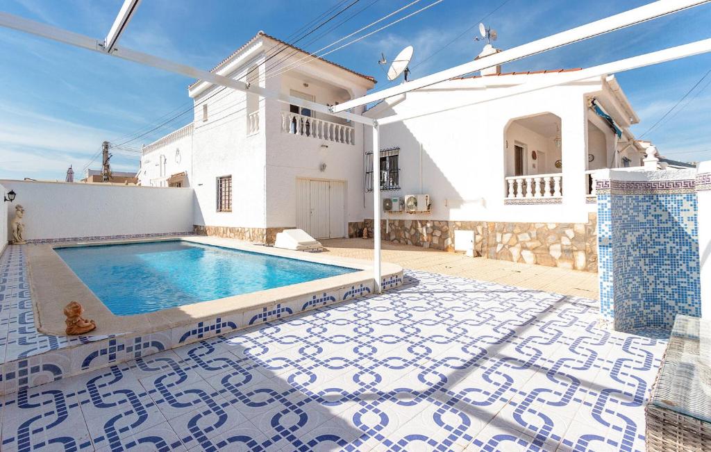 a villa with a swimming pool in front of a house at 3 Bedroom Beautiful Home In Rojales in Rojales