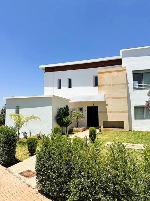 a large white building with a garden in front of it at Villa - Royal Golf de Fez - Pool in Fez