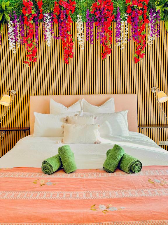 a bedroom with a bed with flowers hanging from the wall at Spacious, minimalist, chic "Maison de Fleurs" in Malgrate