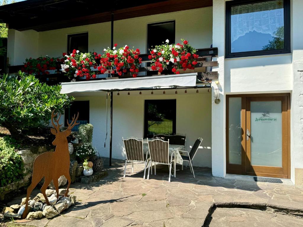 a house with a table and chairs and flowers at Ferienwohnung Alpenhirsch Schwangau in Schwangau