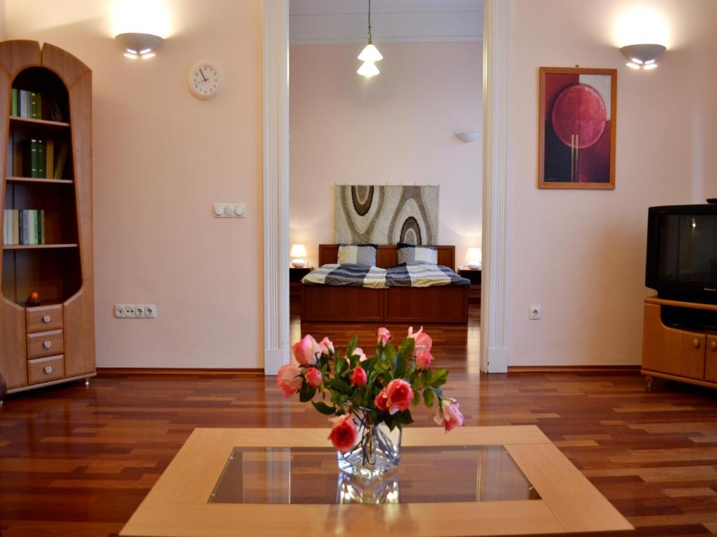 una sala de estar con un jarrón de flores sobre una mesa en Gabriel Apartment, en Budapest