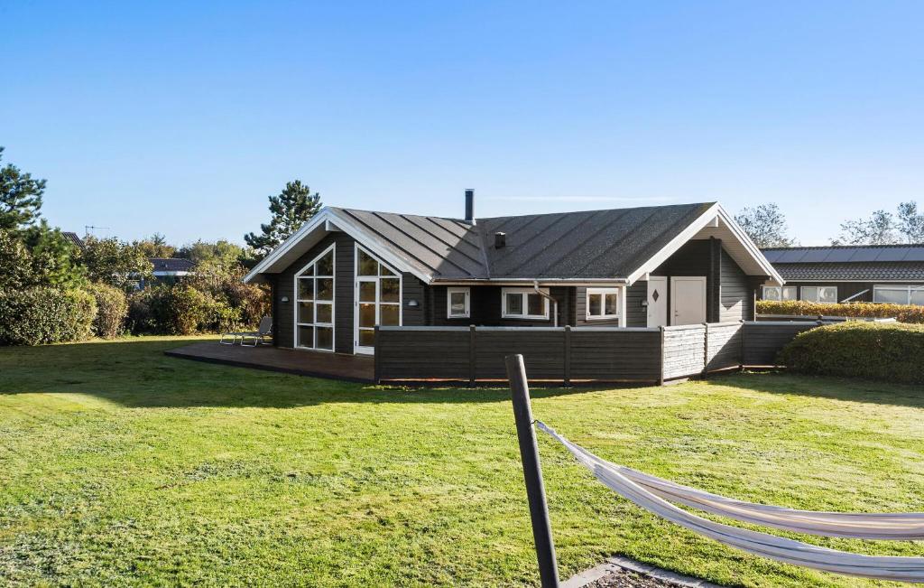 a house with a hammock in front of a yard at Amazing Home In Tarm With Sauna in Tarm