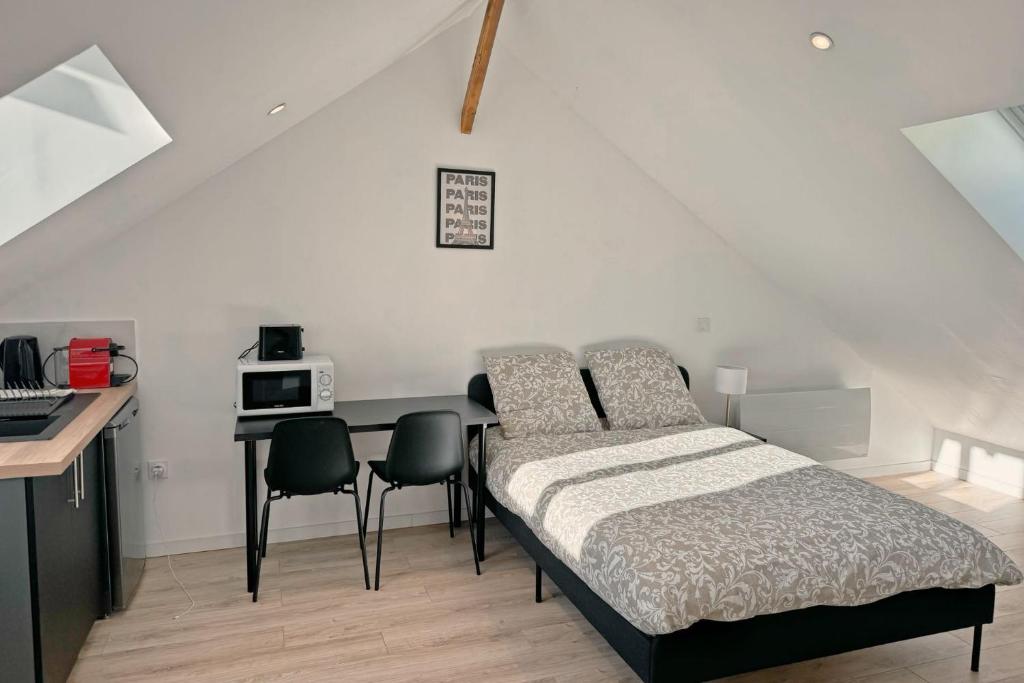 a bedroom with a bed and a table with chairs at Cozy Paris Gateway Studio with free parking in Vitry-sur-Seine