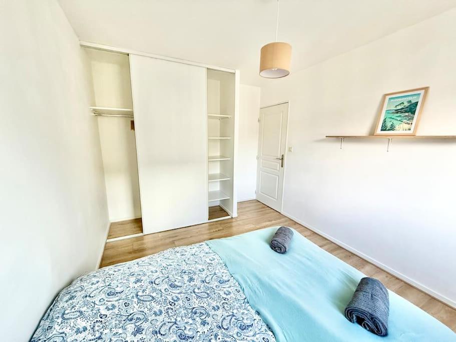 une chambre avec un lit bleu avec deux oreillers dessus dans l'établissement Appartement deux chambres Brest centre proche Tram, à Brest