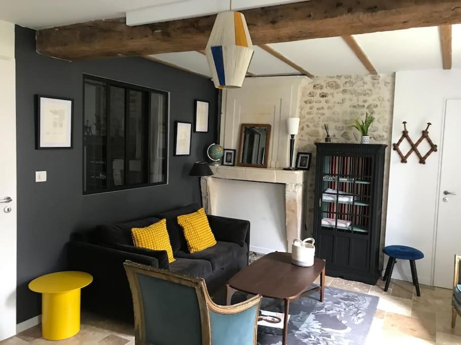 un salon avec un canapé noir et une table dans l'établissement Appartement Talmont sur Gironde, à Talmont-sur-Gironde
