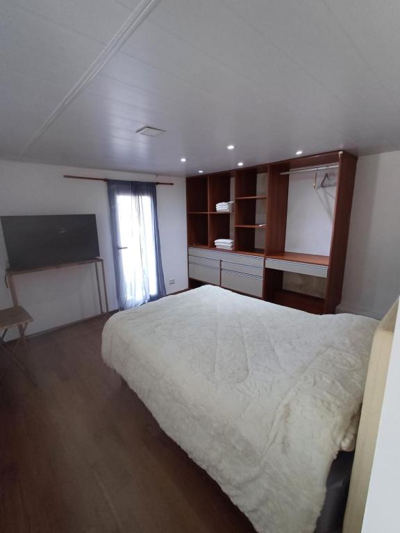 a bedroom with a large white bed and a window at TemporarioCasaLoft in Posadas