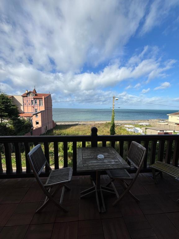 a table and chairs on a balcony with a view of the ocean at Face à la mer, Trouville sur mer in Trouville-sur-Mer