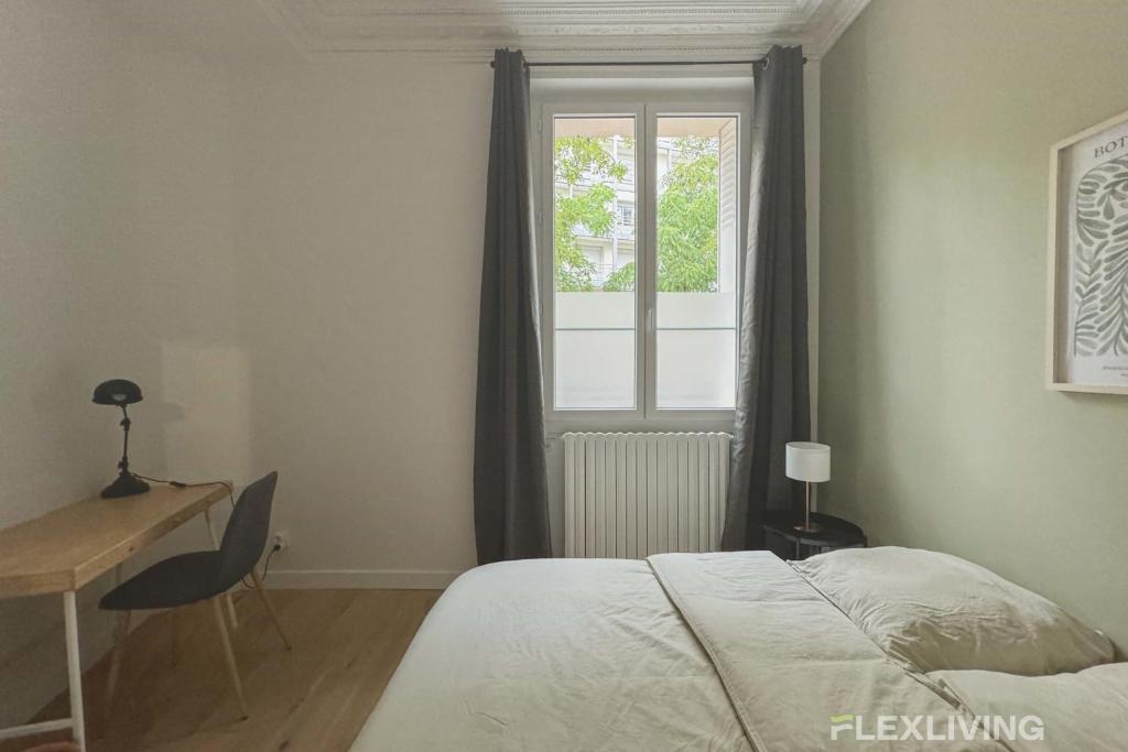 une chambre avec un lit, un bureau et une fenêtre dans l'établissement Flexliving - 99 Felix Faure - Whole apartment, à Paris