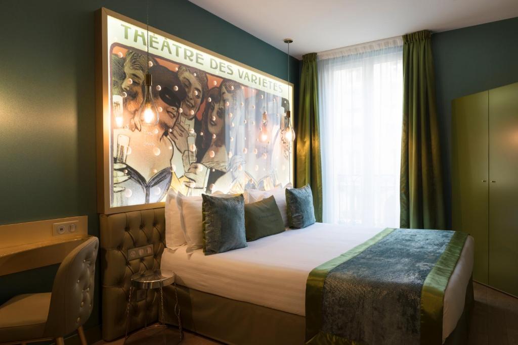 une chambre d'hôtel avec un lit à baldaquin sur le mur dans l'établissement Hotel Les Bulles De Paris, à Paris