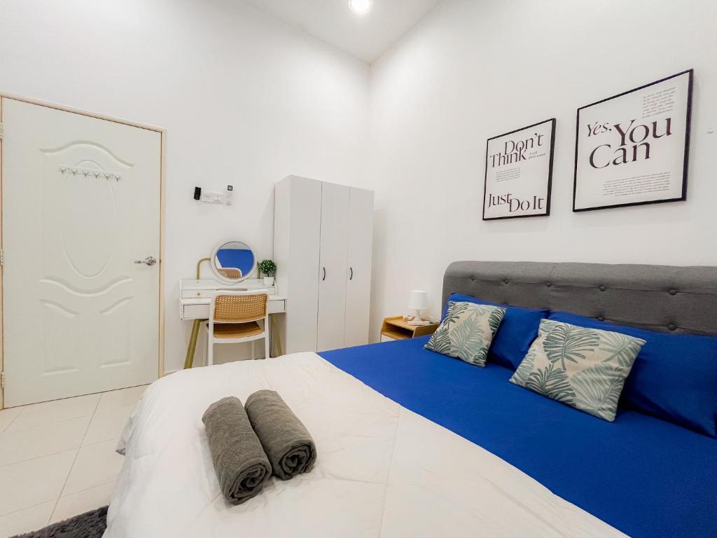 a bedroom with a blue and white bed and a desk at KotaSas Summer East Persint 5 by AHM Home in Kuantan