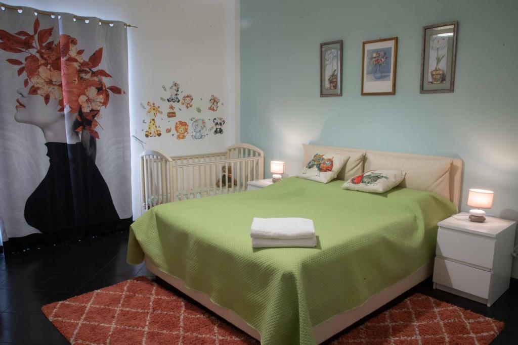 a bedroom with a green bed with two tables and two lamps at Appartamento Terrazza Bella Vista in Cisternino