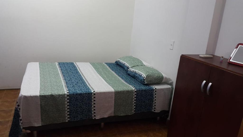 un letto con due cuscini sopra accanto a un comò di Guarani Encarnación a Encarnación
