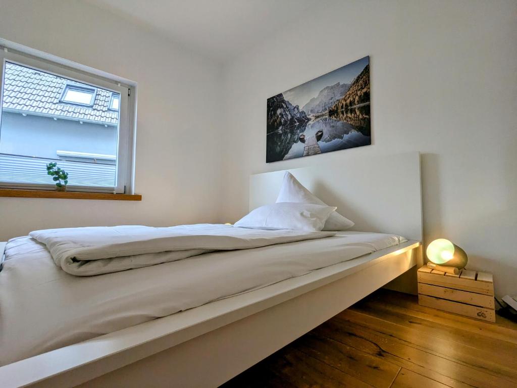 une chambre avec un lit blanc avec une fenêtre dans l'établissement 55qm Messe Wohnung, Trade Fair, 6 Minuten zur Messe, à Rheinstetten