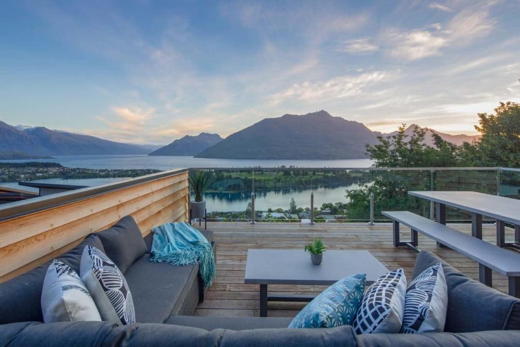 a couch on a deck with a view of the water at Highlands Apt- Lake Views- Free Parking- AC- BBQ in Queenstown