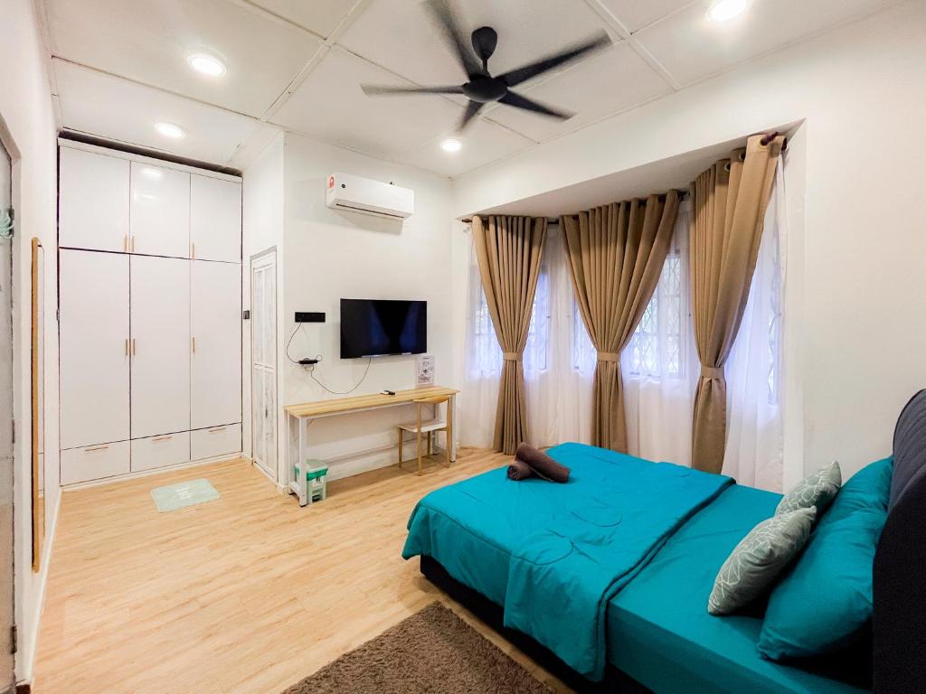 a bedroom with a blue bed and a flat screen tv at Bukit Setongkol Resident LKNP by AHM Home in Kuantan