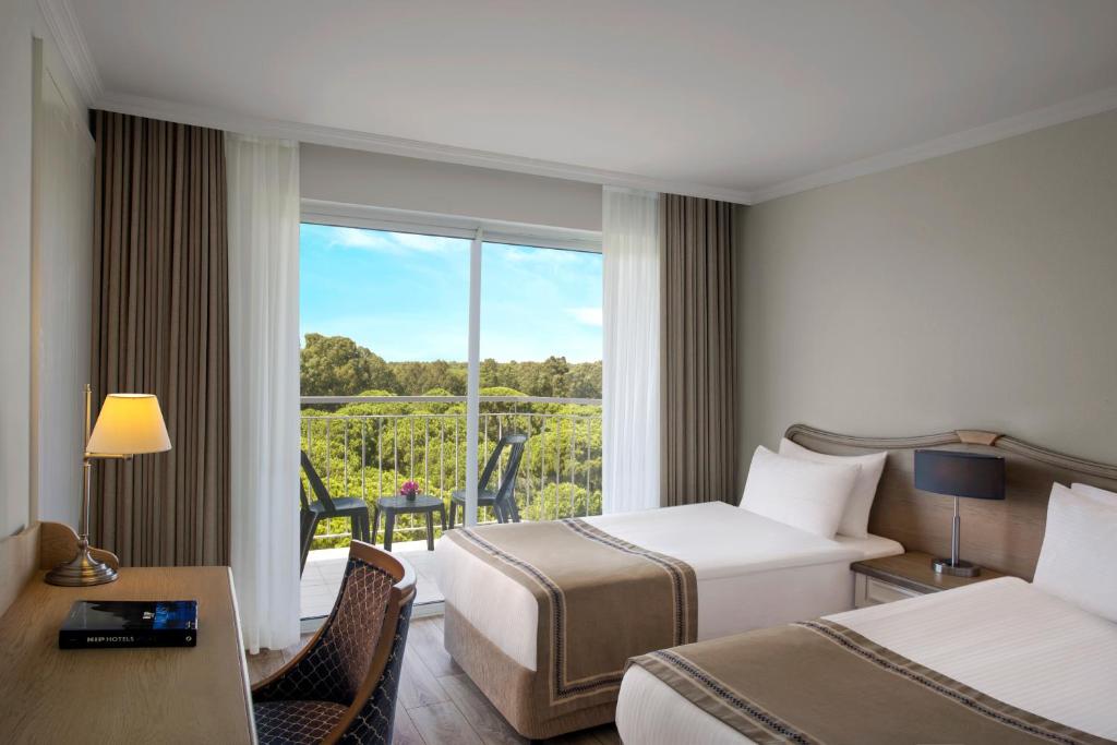 a hotel room with two beds and a balcony at IC Hotels Santai Family Resort - Kids Concept in Belek
