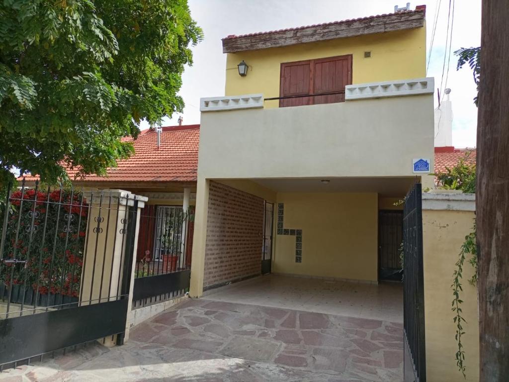 a house with a gate in front of it at Apartamento Confortable Samai Huasi in Las Grutas