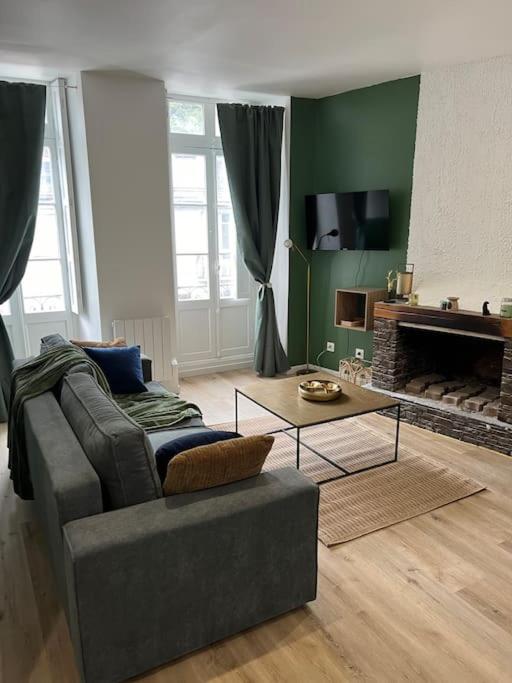 un salon avec un canapé et une table basse dans l'établissement Le Chaleureux Luchonnais, à Luchon