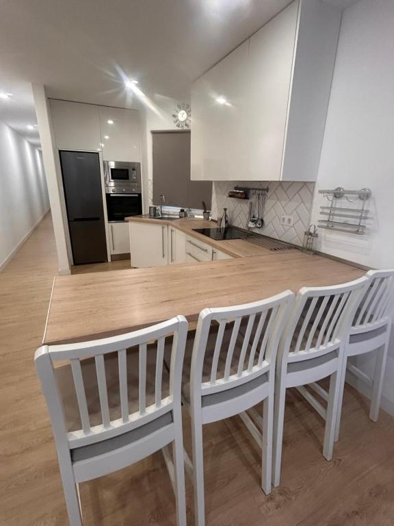 cocina con mesa de madera y 2 sillas blancas en Padre Anchieta 35 - 5, en Santa Cruz de Tenerife