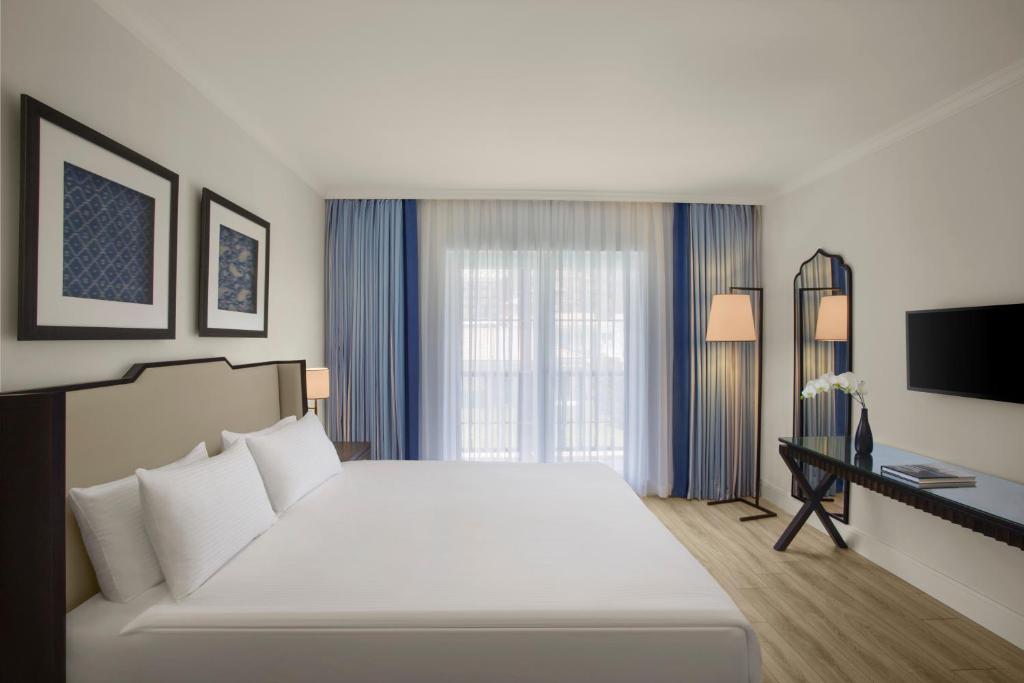 a bedroom with a large white bed and a desk at IC Hotels Santai Family Resort - Kids Concept in Belek