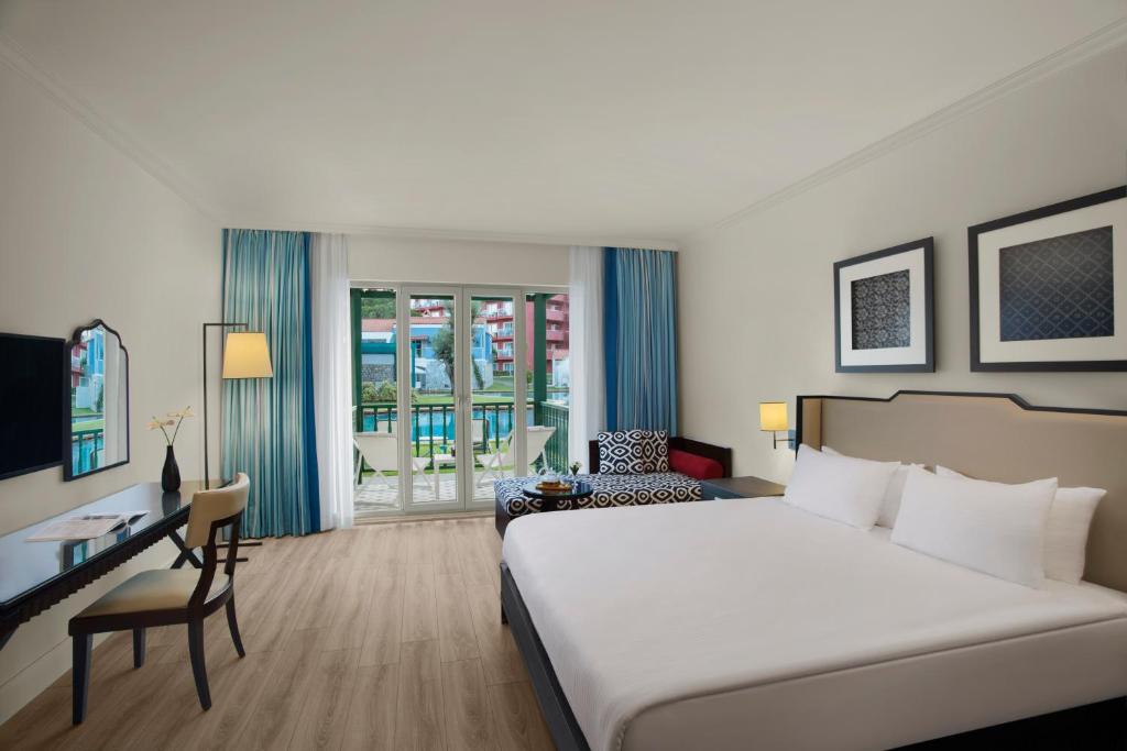 a hotel room with a large bed and a desk at IC Hotels Santai Family Resort - Kids Concept in Belek