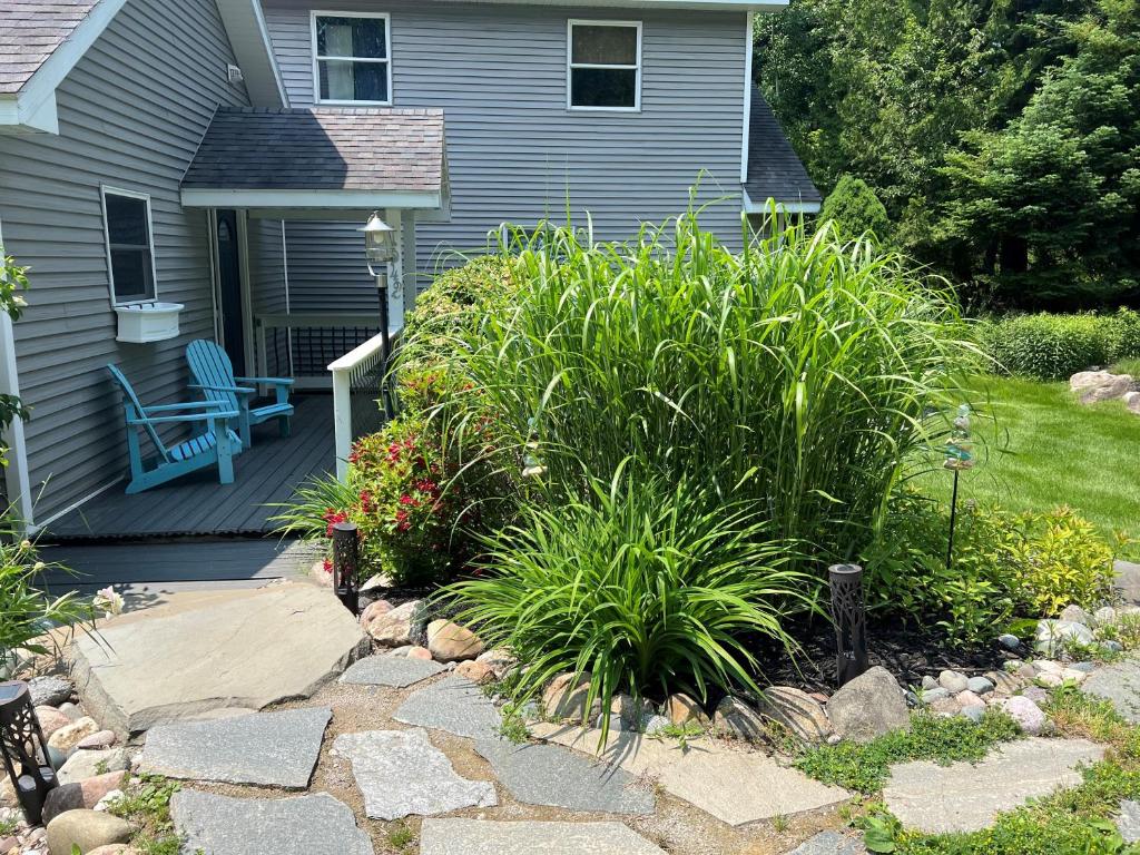 a house with a patio with a bench and plants at Slice of River Life in Traverse City