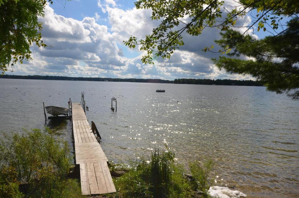 un molo su un lago con una barca in acqua di Splash Landing-Long Lake-Traverse City a Traverse City