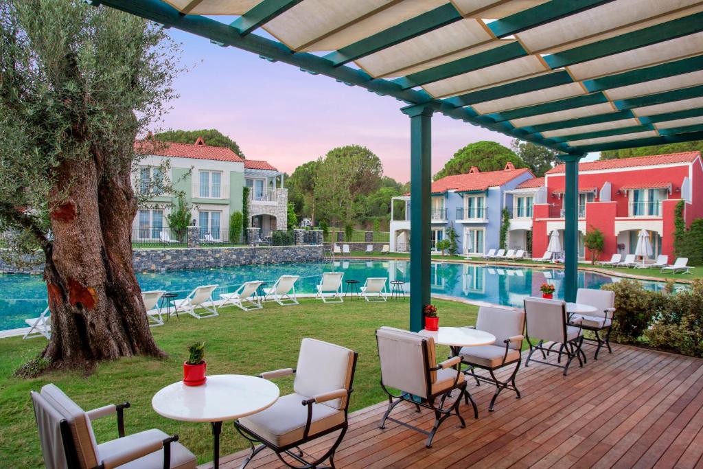 a patio with tables and chairs next to a pool at IC Hotels Santai Family Resort - Kids Concept in Belek