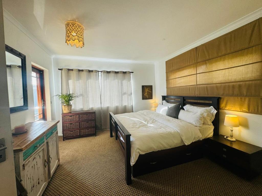 a bedroom with a large bed with a wooden headboard at Clearwater view in Cape Town