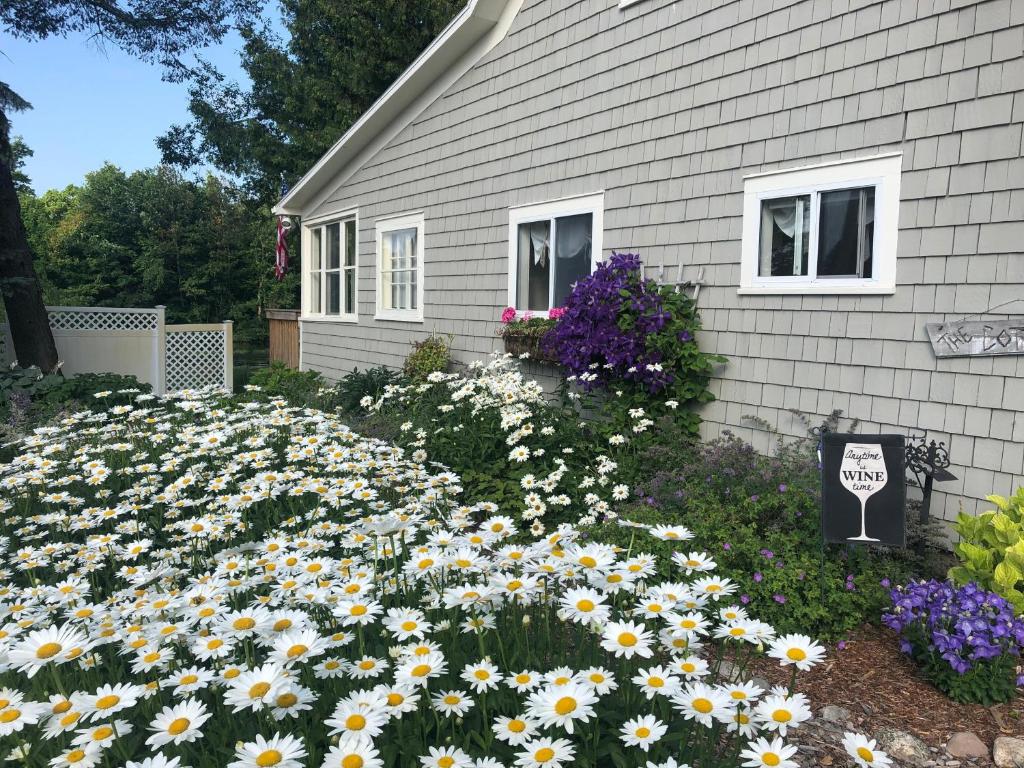 a yard full of flowers in front of a house at On Belanger Pond in Suttons Bay