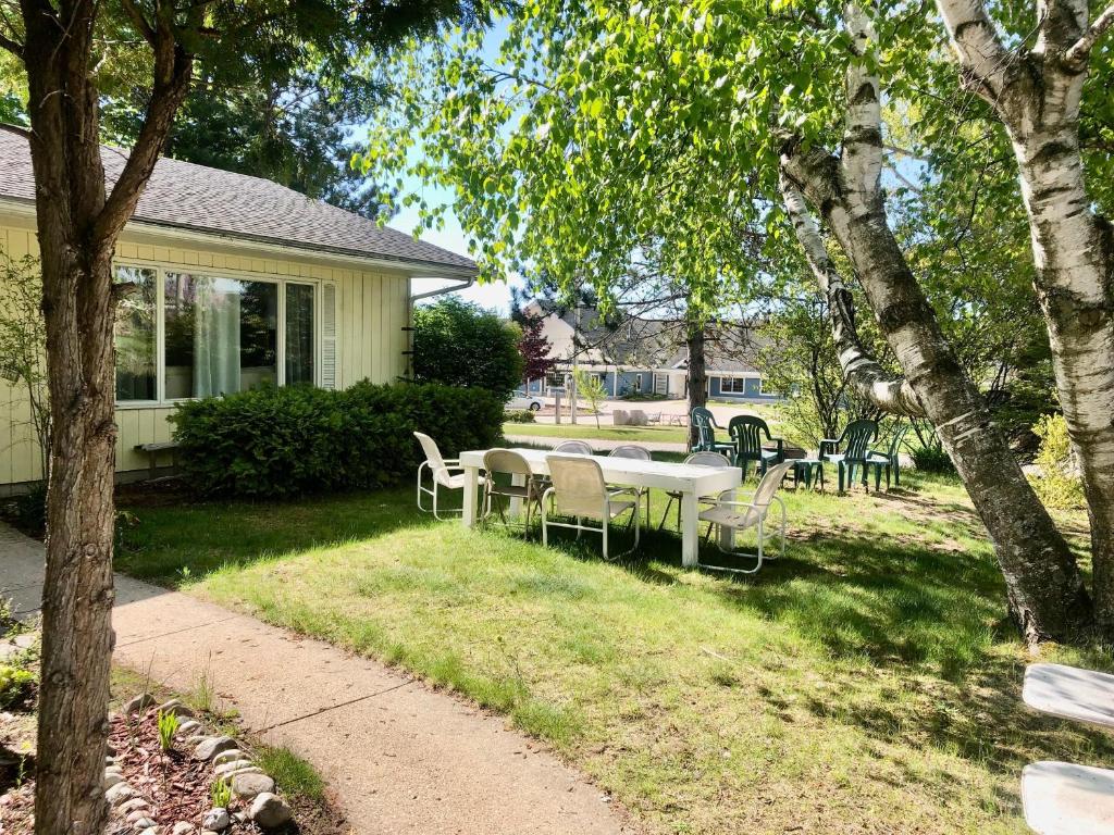 ein Tisch und Stühle im Hof eines Hauses in der Unterkunft Suttons Bay Sunshine in Suttons Bay