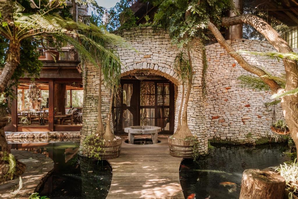un edificio de piedra con un estanque delante de él en Wonderland Boutique Guesthouse & Spa, en Hout Bay