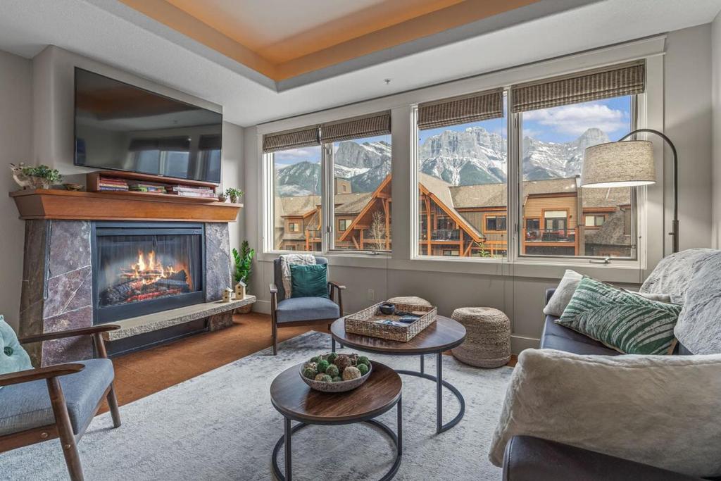 a living room with a fireplace and a mountain view at Luxury Rockies Retreat 1BR with Views in Canmore