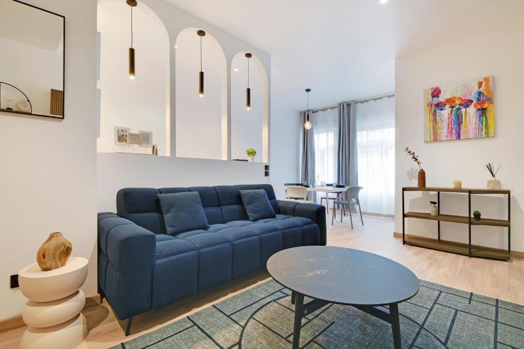 un salon avec un canapé bleu et une table dans l'établissement Le chic à Paris 4P BERCY - DAUMESNIL, à Paris
