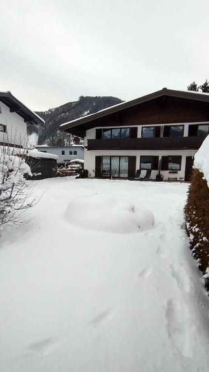 pokryty śniegiem dziedziniec przed budynkiem w obiekcie Apartment-Alpenfantasie w mieście Zell am See