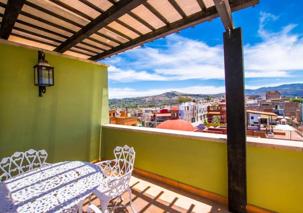 サンミゲル・デ・アジェンデにあるCasa Eugenia, tu hogar en San Miguel de Allendeのテーブルと椅子があり、街の景色が見えるバルコニー