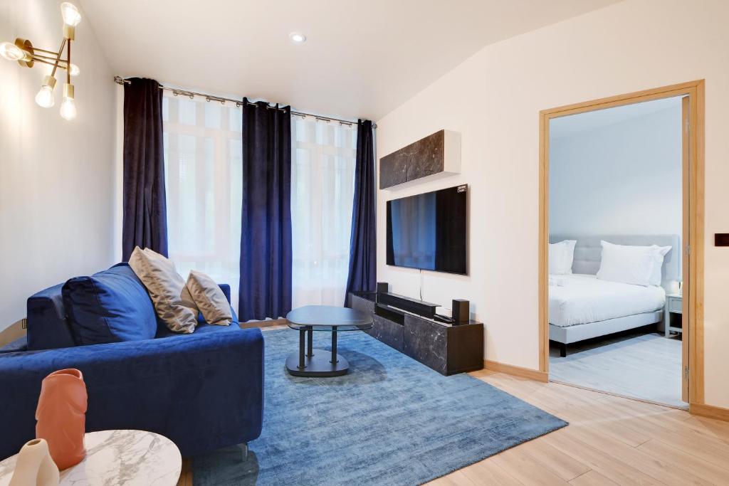 - un salon avec un canapé bleu et un lit dans l'établissement Elegance a paris 4P BERCY - DAUMESNIL, à Paris