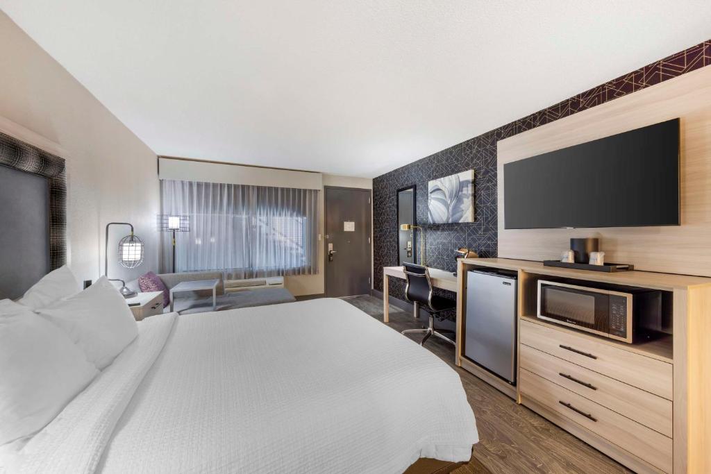 a hotel room with a bed and a flat screen tv at Aiden by Best Western South Reno in Reno