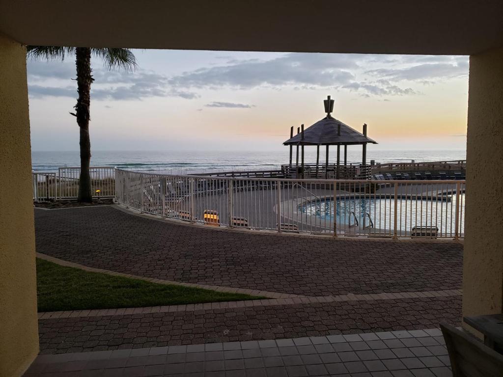 a gate with a gazebo next to the ocean at Summer House 103A by Vacation Homes Collection in Orange Beach