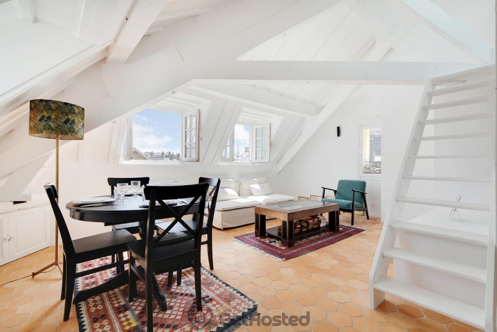 une salle à manger avec une table et un salon dans l'établissement Ile de la Cite - Seine & Notre Dame View, à Paris