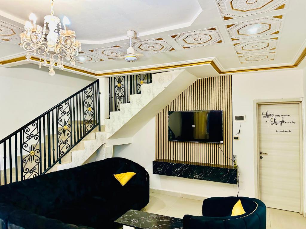 a living room with a black couch and a staircase at VILLA AMINA 2 splendida residenza ideale per vacanza in famiglia in Garguen