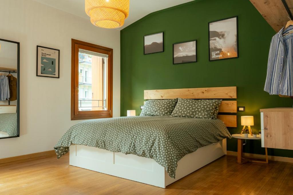 una camera da letto con una parete verde e un letto di Treviso City Center BnB - Comodo per Stazione e Centro Città a Treviso
