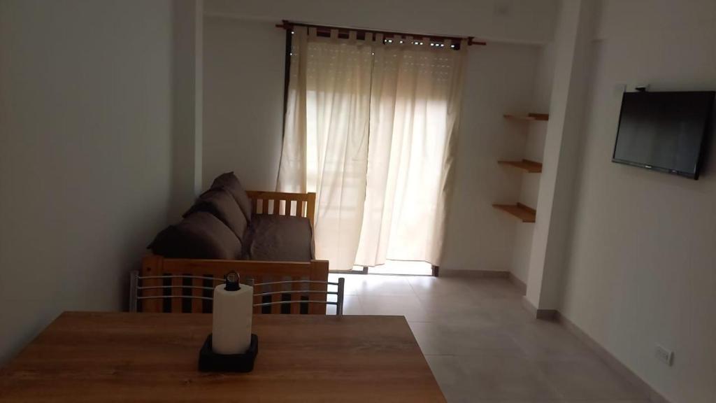 a living room with a table and a couch and a window at Depto 41 in Santa Teresita